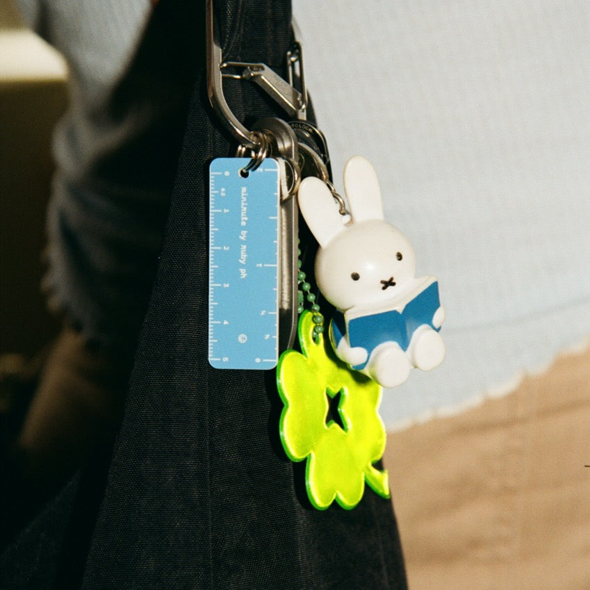 Keychain with cartoon character and ruler attached to a bag