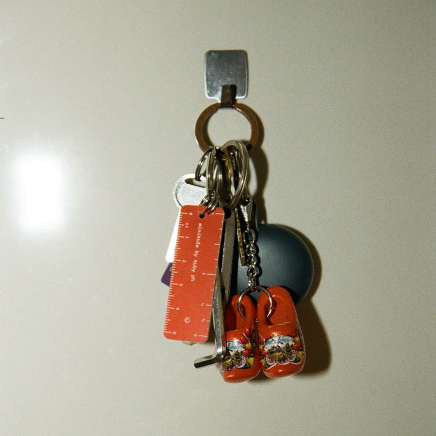 Keychain with trinkets and a ruler on a white surface